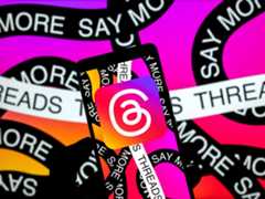 Person holding up a phone showing the Threads logo and colors