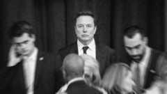 Elon Musk in black and white with blurred people around him