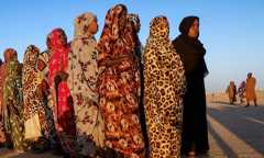 Des femmes déplacées font la queue en attendant de recevoir une aide, dans le camp d'Al-Dabbah, au Soudan, le 19 novembre 2025