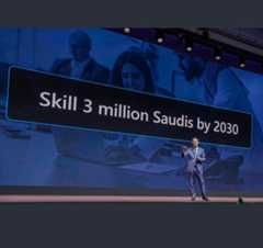 Man on stage in front of a banner reading "Skill 3 million Saudis by 2030."