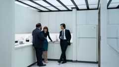 Severance Season 2 - Three cast members stood inside a clinical white kitchen setting.