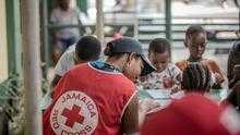 A Jamaica Red Cross volunteer provides psychosocial support to children affected by Hurricane Melissa.