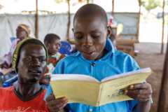 A boy reads from a Keliko grammar book during a literacy class.