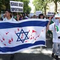 Protesters hold an Israeli flag stained with red paint at an anti-Israel demonstration in Madrid, Spain, on May 11, 2024.(Pierre-Philippe Marcou/AFP) Protesters hold an Israeli flag stained with red paint at an anti-Israel demonstration in Madrid, Spain, on May 11, 2024.(Pierre-Philippe Marcou/AFP)