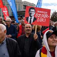 A protester holds a banner with the pictures of jailed Istanbul Mayor Ekrem Imamoglu during a rally organized by the country's main opposition party, the Republican People's Party (CHP), to protest the suspension and imprisonment of Istanbul Mayor, in Istanbul on October 26, 2025. (Yasin AKGUL / AFP) A protester holds a banner with the pictures of jailed Istanbul Mayor Ekrem Imamoglu during a rally organized by the country's main opposition party, the Republican People's Party (CHP), to protest the suspension and imprisonment of Istanbul Mayor, in Istanbul on October 26, 2025. (Yasin AKGUL / AFP)
