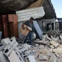 A Palestinian man carries a cardboard box as he stands on the rubble of a house that was reportedly demolished by Israeli settlers the previous day in Al-Duyuk Al-Tahta, a village on the outskirts of Jericho, in the West Bank, on February 11, 2026. (AHMAD GHARABLI / AFP) A Palestinian man carries a cardboard box as he stands on the rubble of a house that was reportedly demolished by Israeli settlers the previous day in Al-Duyuk Al-Tahta, a village on the outskirts of Jericho, in the West Bank, on February 11, 2026. (AHMAD GHARABLI / AFP)
