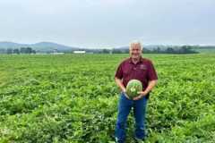 George McDonald holding a watermelon in a field