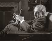Teller, later in life, at home seated with a book in front of his fireplace