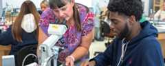 An instructor assisting a student with a microscope in a science laboratory at the Kent State University Geauga Twinsburg Academic Center.