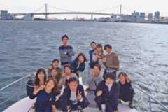 ミッドブルー1階前方デッキでレインボーブリッジとともに記念撮影をする一行