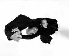 A wide-angle black-and-white photograph of two people demonstrates the capabilities of the Ultra Wide camera on iPhone 17 Pro