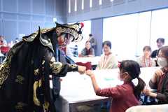 中国・無錫市との友好都市締結40周年を記念したイベントで、来場者と交流する変面師の王文強さん(左)=2025年11月22日、相模原市緑区、関田航撮影