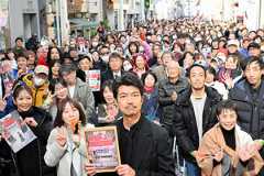 集まった人たちと一緒に写真撮影に応じた俳優の仲村トオルさん(中央)=2025年12月13日午後1時28分、静岡市清水区、鵜飼啓撮影