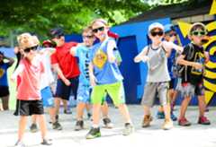 Campers on stage outside dancing with sunglasses on