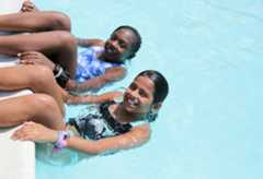 Two campers in the pool hanging off of the edge