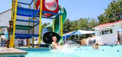 Camper sliding down a waterslide into a pool