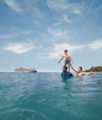 Family enjoying the water by a Carnival ship