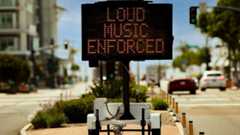 Digital sign stating Loud Music Enforced in an urban area in attempt to reduce loud music from cars or boom boxes