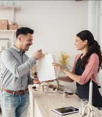 店舗内のカウンターで、客の男性が支払った商品を手渡す店員の女性