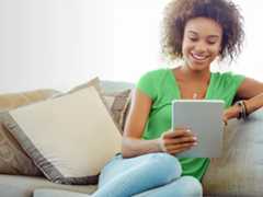 woman sitting on a couch with an tablet in hand