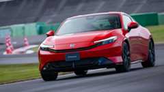 Front 3/4 view of a red 2026 Honda Prelude driving on track
