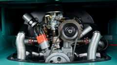 A Volkswagen Bus parked, showing its air-cooled engine.