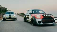 The two cutsom Minis driving next to each other on a seaside road at dusk