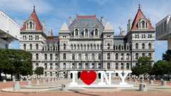 New York state capitol building with an "I love New York" sign out front