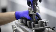 A technician assembling a Mercedes-AMG four-cylinder engine