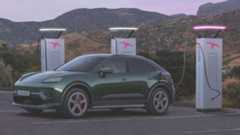 A Green 2024 Porsche Macan 4S electric, charging in front of mountains