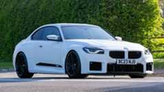 White BMW M2 parked on the road.