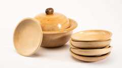 Ausstellung Formen der Anpassung Mehrere Holzteller und eine Holzschüssel mit Deckel