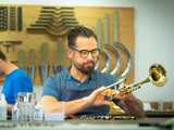 Vogt Instrumente Leipzig Ein Handwerker fertigt ein Blasinstrument in einer Werkstatt