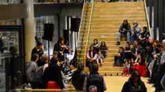 Teaser Bild - Kultur-und Freizeitangebote / Geflüchtete aus der Ukraine Besucher/-innen hören Musiker/-innen bei entspannter Atmosphäre im Museum zu