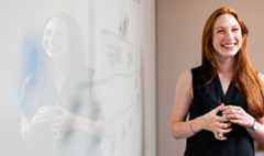 Teacher smiling and standing at whiteboard