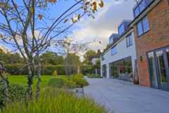 Seen from one end, Urban Grey Porcelain patio, by Karen McClure Garden Design, stretches across width of house, lawn on left.***Design by Karen McClure Garden Design, www.karenmcclure.co.uk | Built by Langdale Landscapes, www.langdalelandscapes.co.uk