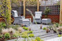 Patio of Platinum Plank Paving edged by walls with grey trellis. Low planting in beds. Built by VU Garden Design and Landscaping.***Vu Garden Design & Landscaping, www.vugarden.co.uk