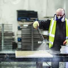 Man in protective equipment sealing natural stone in London Stone Bespoke Stone Centre