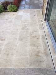 Leaf marks visible on Beige sawn sandstone patio after jet washing.
