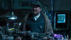 The Tinkerer smiling over several gadgets