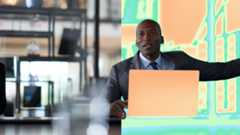 A man in a suit and tie sitting in front of a laptop