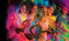 Noored tüdrukud osalevad värvikirevas treeningus neonvalgustuse all.