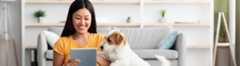 Woman smiling with her dog on her tablet researching audience measurement solutions relevant to audiences.