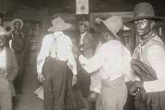 A few men look straight on while others move around ia room.