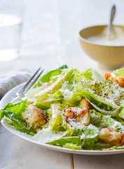 Fork on a plate with a Caesar salad.