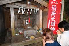 越沢稲荷に手を合わせる参拝者ら=ときがわ町椚平