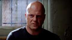 Vic Mackey sitting in a dark room on