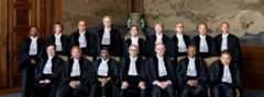Judges posing for photo in the Peace Palace Several judges in robes posing for photo, some seated, some standing behind