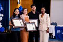 students hold up candles at convocation