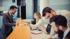 banking-photography-website-blog-manager-with-staff-1280x720.jpg A young man is standing at a bank counter. Because of the good negotiation skills of an efficient employee, he decided to cooperate with her and sign a contract.